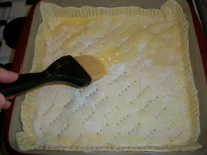 Brush egg wash over puff pastry.