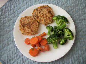 Salmon croquettes served with steamed broccoli and herbed carrots.